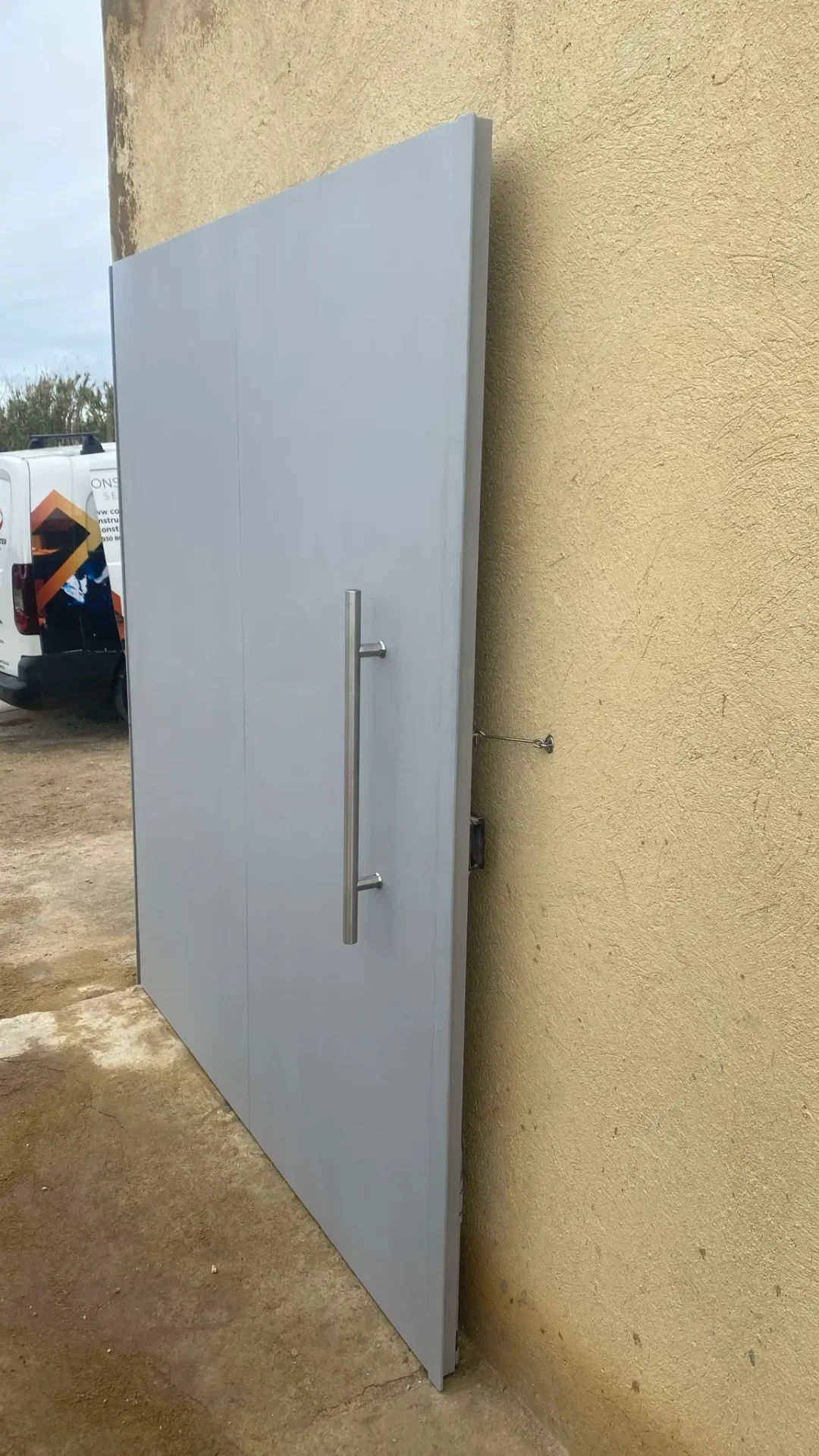 Porta metálica de segurança com puxador vertical, instalada em acesso exterior de moradia em Lisboa