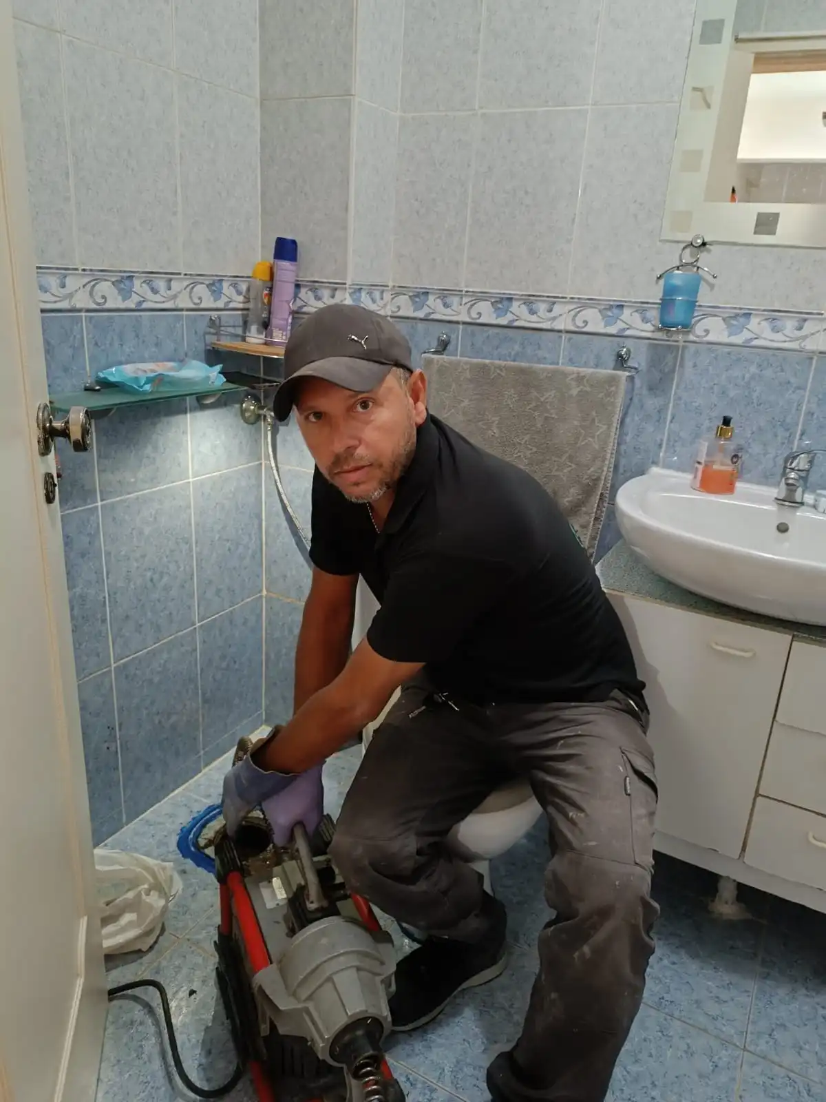 Técnico a efetuar desentupimento em casa de banho.