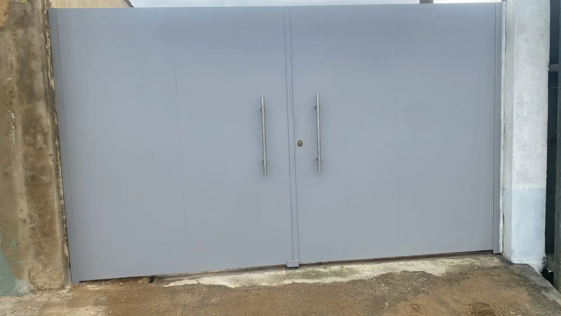 Portões metálicos duplos lisos, feitos à medida e instalados em propriedade residencial na zona de Lisboa